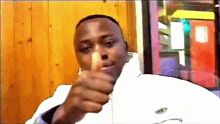 a man wearing a white jacket is giving a thumbs up