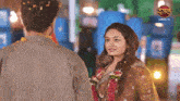 a man and a woman are looking at each other with a dangal tv logo in the background .