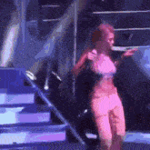 a woman in a pink outfit is standing on a stage