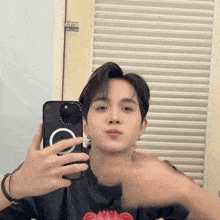 a young man is taking a selfie in front of a mirror .