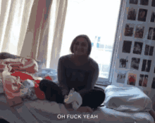 a woman is sitting on a bed with the words oh fuck yeah written below her