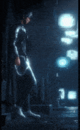 a man leaning against a wall in a dark room holding a sword