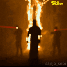 a silhouette of a man standing in front of a fire with a pari match logo on the bottom