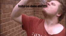 a man in a red shirt is drinking from a bottle with the words " haha ive done eht !!! " on the bottom