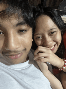 a man and a woman are holding hands and smiling for a picture