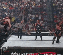 a wrestling match is taking place in front of a crowd and a sign that says world wrestling