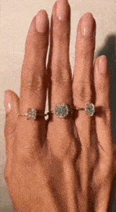 a woman 's hand with three rings on her fingers