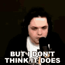 a man wearing headphones is talking into a microphone and saying `` but i don 't think it does ''