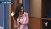 a woman is holding a pool cue in front of a sign that says mas adelante en vivo