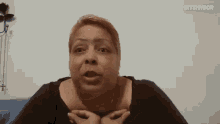 a woman is crying while sitting on a blue couch in front of a white wall .