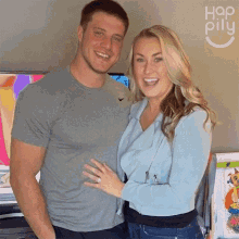 a man and a woman are posing for a picture in front of a wall that says hop pilly