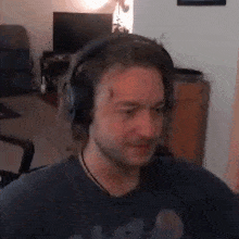 a man wearing headphones is sitting in a chair in a room .