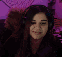 a woman wearing headphones with a purple background