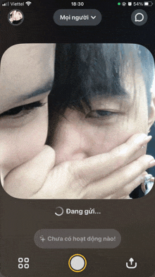 a phone screen shows a man and woman covering their mouths