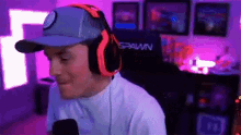 a man wearing headphones and a baseball cap is sitting in a chair in a room .