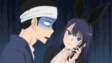 a man with a bandage on his head looks at a girl with bunny ears