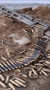 a machine gun with a lot of bullets on the ground