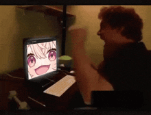 a man is sitting in front of a computer screen with a girl on it