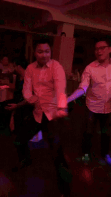 a man in a white shirt is dancing in a red room