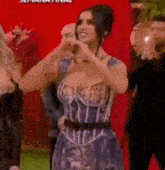 a woman in a corset dress is making a heart shape with her hands .