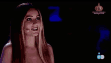 a woman with long hair is smiling in front of a microphone on a television screen .
