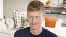 a man wearing glasses and a mustache is making a sad face