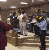 a group of people standing in a room with a man wearing a mask that says ' i ' on it
