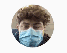 a man with curly hair is wearing a blue mask .