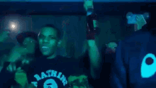 a man holding a microphone in front of a crowd with a shirt that says supreme