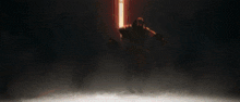 a person is standing in a dark room with a light coming from behind them