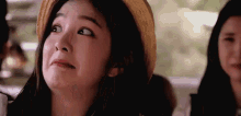 a woman wearing a straw hat is making a face