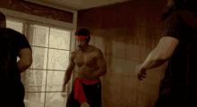 a group of men are standing in a room fighting each other .