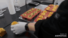 a person is putting a cupcake in a silicone mold and the words made in animotica are visible