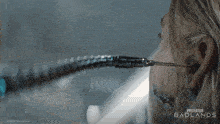 a poster for predator badlands shows a woman holding a chain in her ear