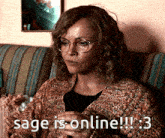 a woman wearing glasses is sitting on a couch and says sage is online 3