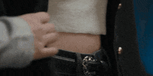 a person is touching a woman 's stomach with a belt