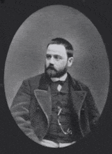a black and white photo of a man pointing at the camera with the words j'accuse written in red