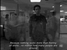 a black and white photo of a man standing in a hospital hallway with a quote behind him