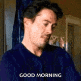 a man in a blue sweater is saying good morning .