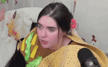a woman wearing a taco costume is talking into a microphone
