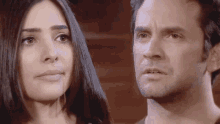 a man and a woman are looking at each other and the woman is crying