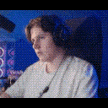 a man wearing headphones is sitting in a chair in front of a computer .