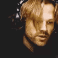 a close up of a man with his eyes closed and headphones on .