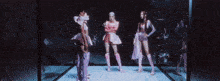 a group of girls are standing in front of a broken glass wall .