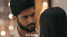 a man with a beard is looking at a woman with the words toh batao below him