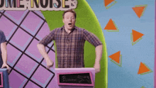 a man in a plaid shirt is standing in front of a podium that says ' bizarre ' on it .