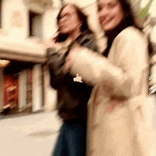 a blurry photo of two women walking down a street