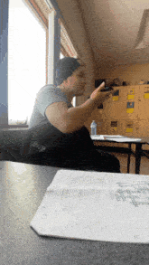 a man sits at a desk in front of a window with a crossword puzzle on it