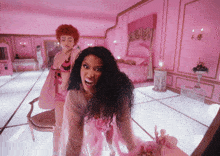 a woman in a pink bathing suit stands next to another woman