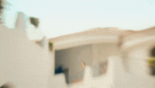 a blurred image of a white building with a blue sky in the background .